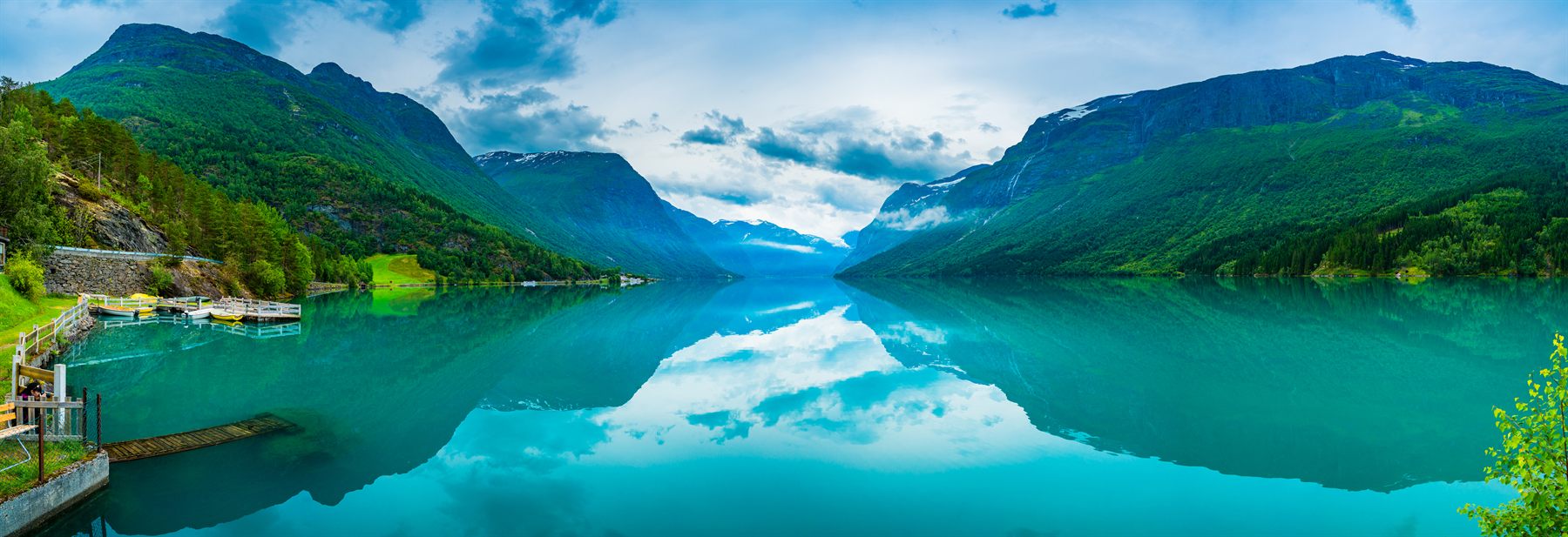 Turquoise Lovatnet lake reflecting steep green mountains in western Norway